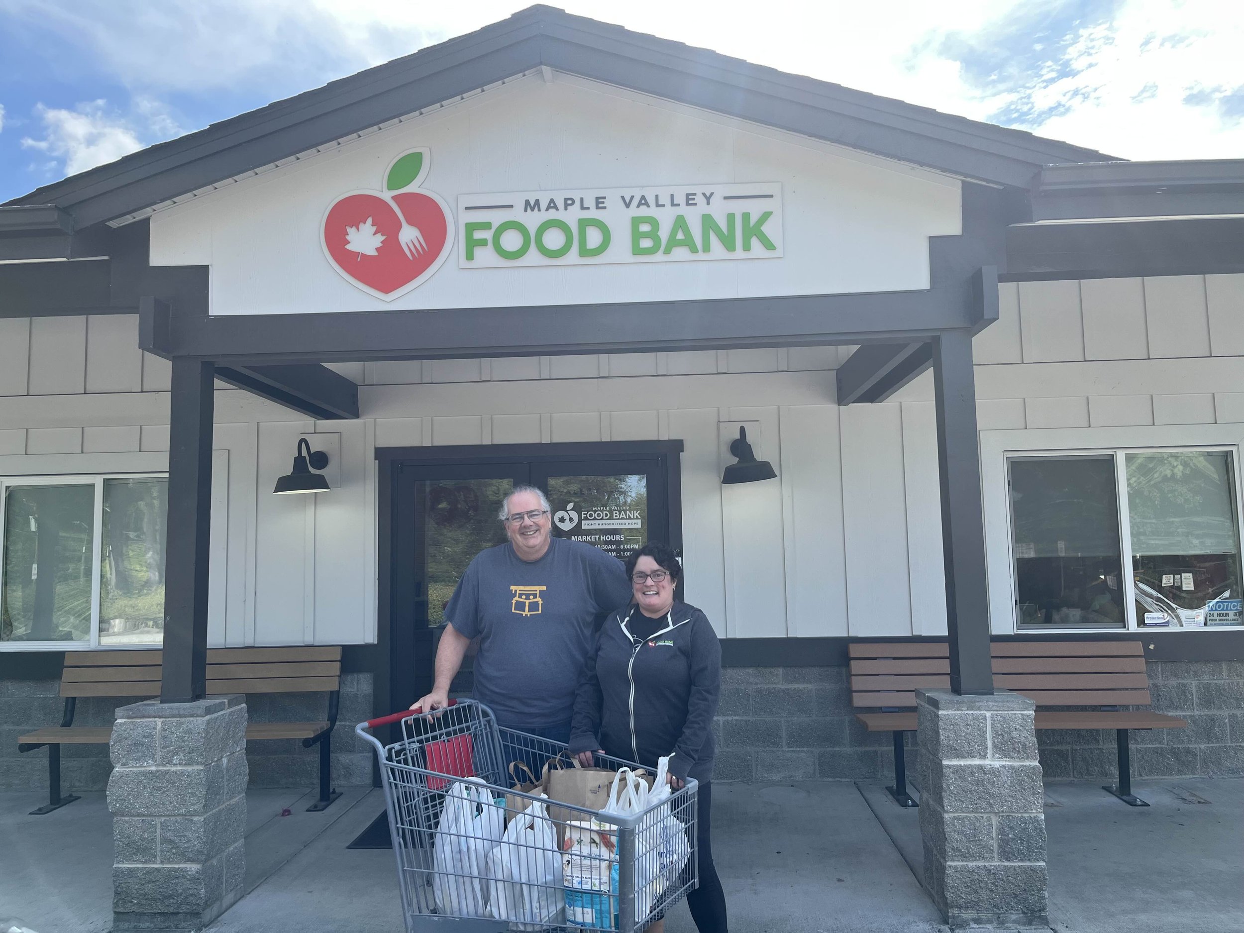 Jude and Tami outside the Maple Valley Food Bank with a cart full of 72 pounds of food donated by the residents of Sawyer's Crest